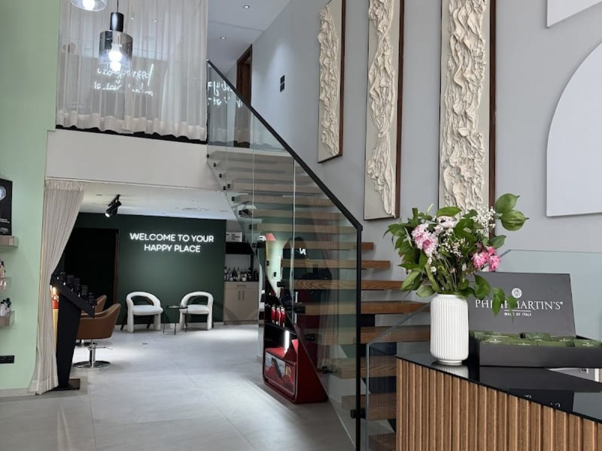 Accueil de Meraki Studio avec néon « Welcome to your happy place »
